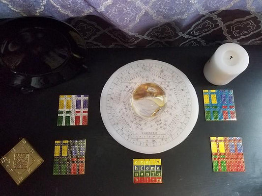 An enochian ritual setup featuring watchtower tablets and a wax sigillum dei aemeth.