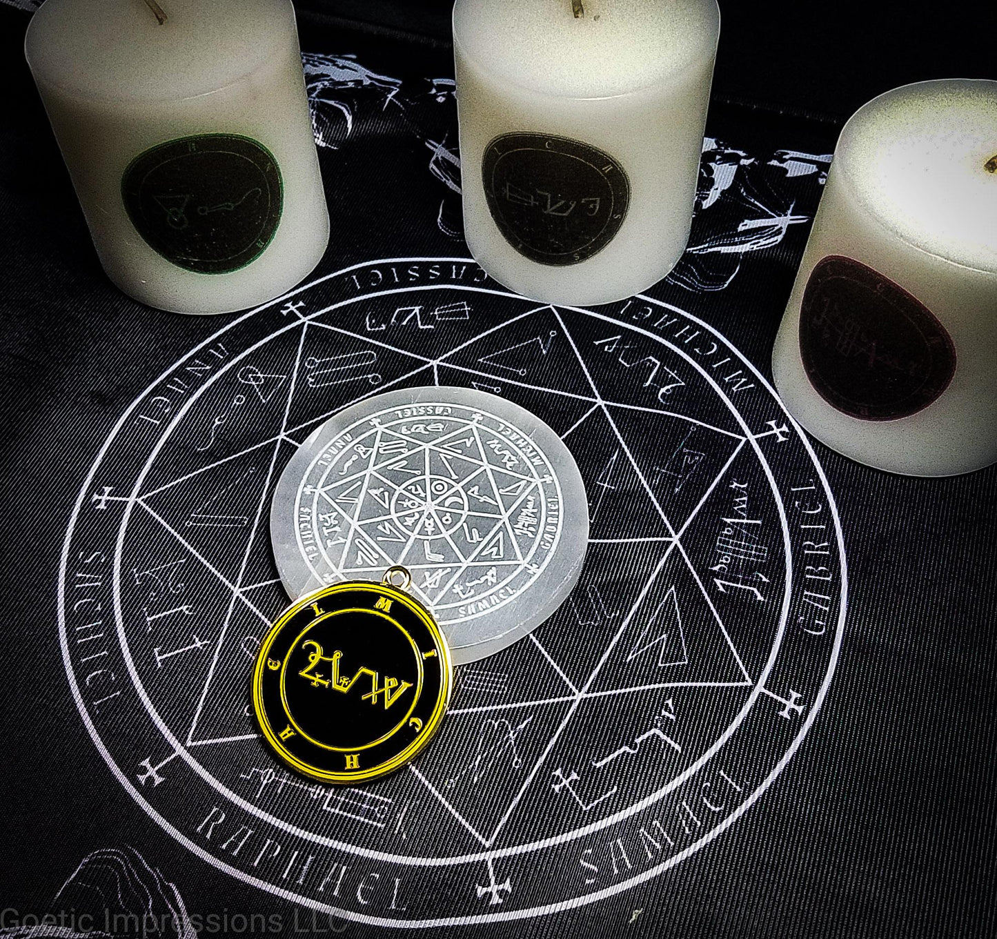 A black and white altar cloth with a seal of the planetary Archangels in the center. The seal contains various astrological sigils. There are candles and other ritual tools on the cloth.