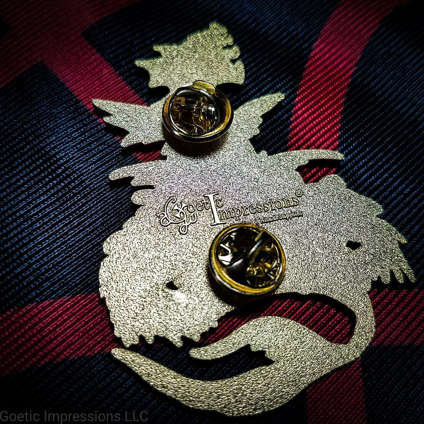 Back of a Leviathan pin featuring the Goetic Impressions stamp and two pin clutches.