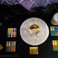 Ritual setup with Enochian watchtower tablets, tablet of union, crystal ball, wax sigillum and golden lamen.