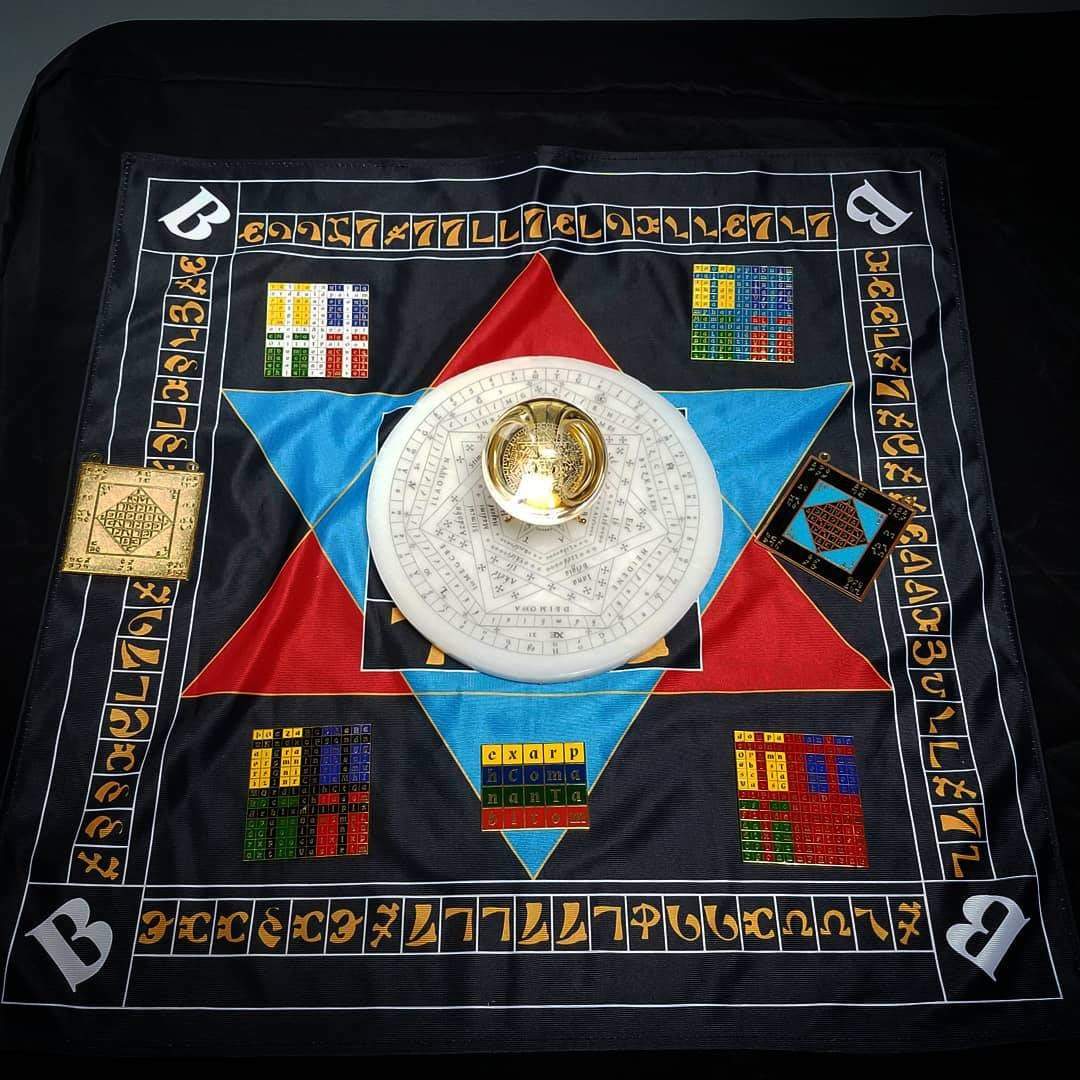 Enochian ritual setup featuring holy table of practice altar cloth, wax sigillum dei aemeth, enochian watchtower element tablets, tablet of union, gold and colored lamens and engraved crystal ball.