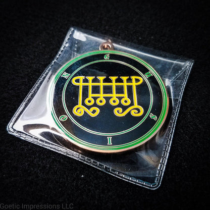 Amulet of Gusion in a PVC pouch. The sigil for Gusion is yellow. Gusion's name is surrounding the sigil with concentric circles in green on a black background. The seal is copper plated.