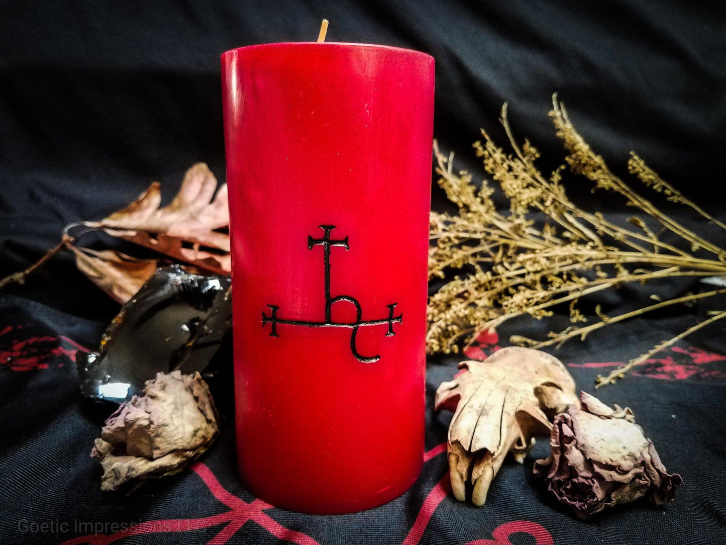 Red pillar candle with black Lilith sigil carved into it.