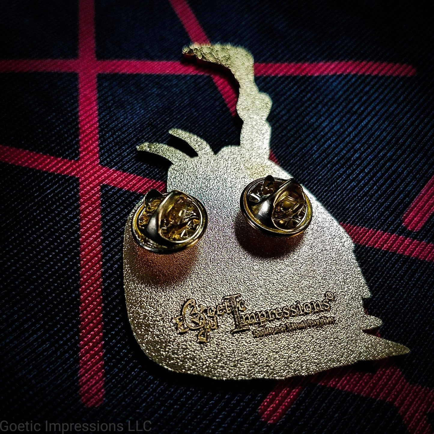Back if a Lucifer pin with a Goetic Impressions stamp and two pin clutches.