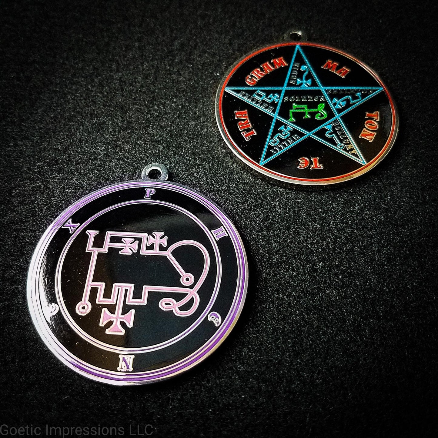 Two silver plated medallions featuring the front and back of the Ars Goetia spirit Phenex. The sigil is pink with the name and circle surrounding in purple. The Reverse is the TETRAGRAMMATON. The pentacle is blue with a red circle. Tetragrammaton is in red. The center sigil is green.
