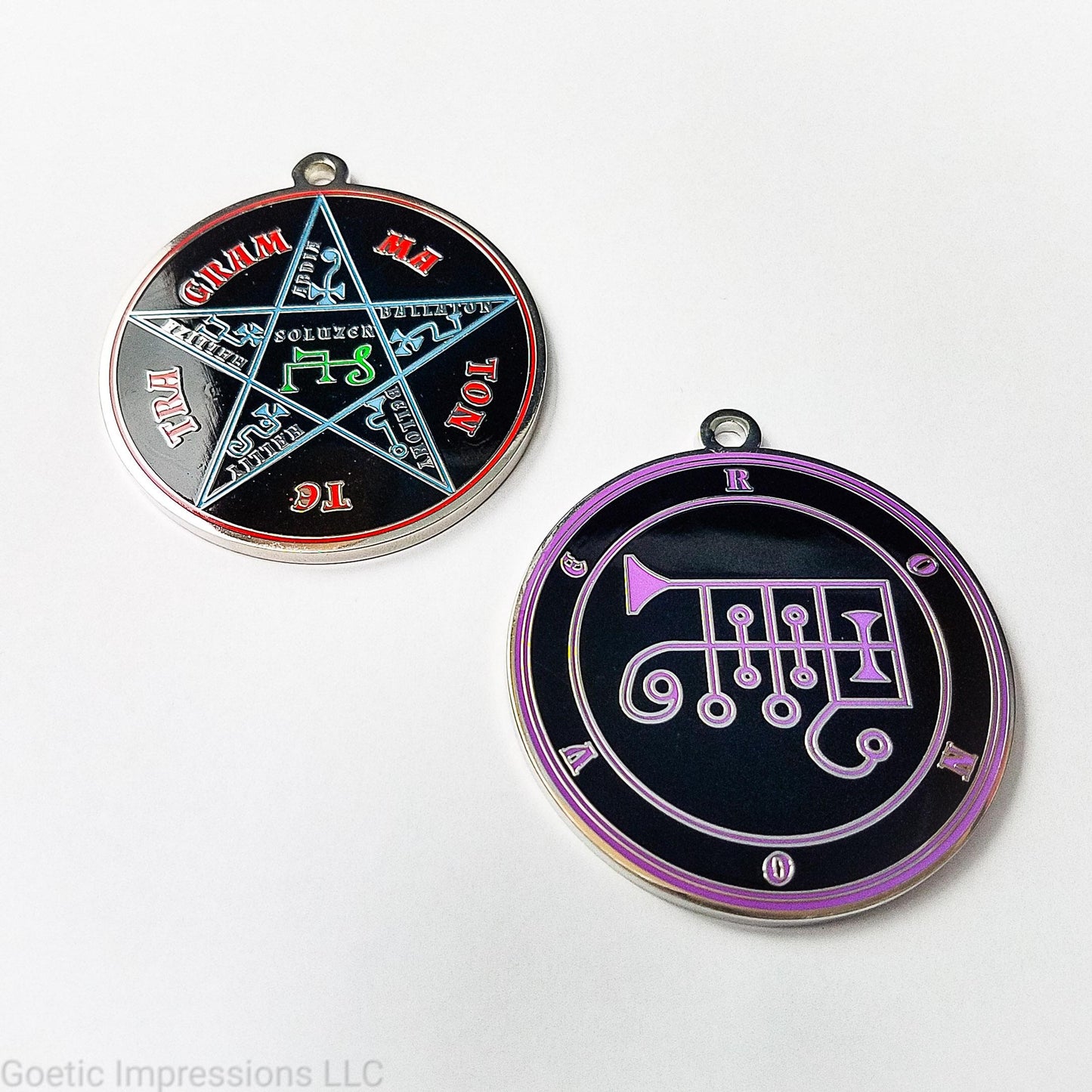 Two silver plated medallions featuring the front and back of the Ars Goetia spirit Ronove. The sigil is purple with the name and circle surrounding in purple. The Reverse is the TETRAGRAMMATON. The pentacle is blue with a red circle. Tetragrammaton is in red. The center sigil is green.