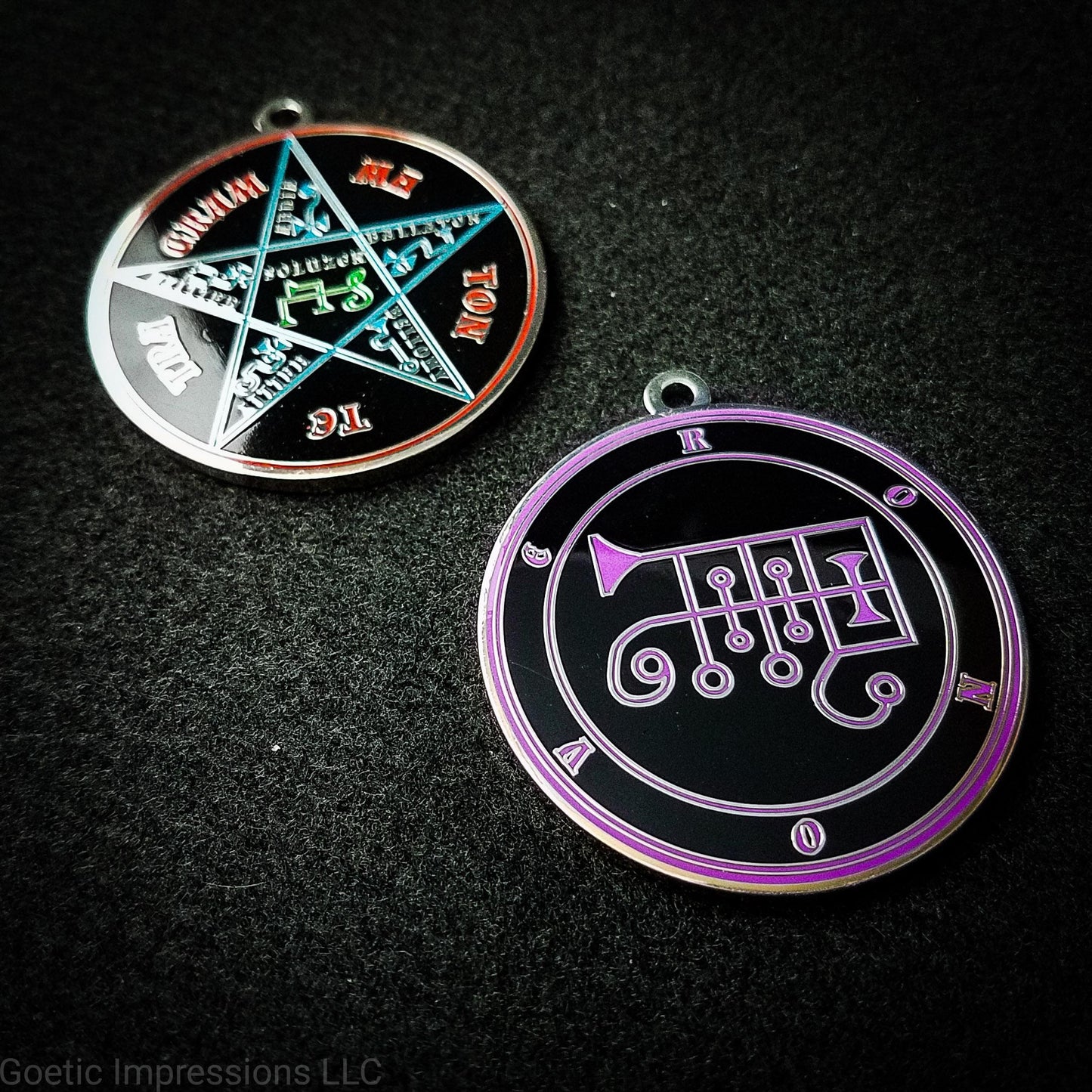 Two silver plated medallions featuring the front and back of the Ars Goetia spirit Ronove. The sigil is purple with the name and circle surrounding in purple. The Reverse is the TETRAGRAMMATON. The pentacle is blue with a red circle. Tetragrammaton is in red. The center sigil is green.