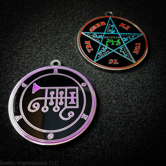 Two silver plated medallions featuring the front and back of the Ars Goetia spirit Ronove. The sigil is purple with the name and circle surrounding in purple. The Reverse is the TETRAGRAMMATON. The pentacle is blue with a red circle. Tetragrammaton is in red. The center sigil is green.