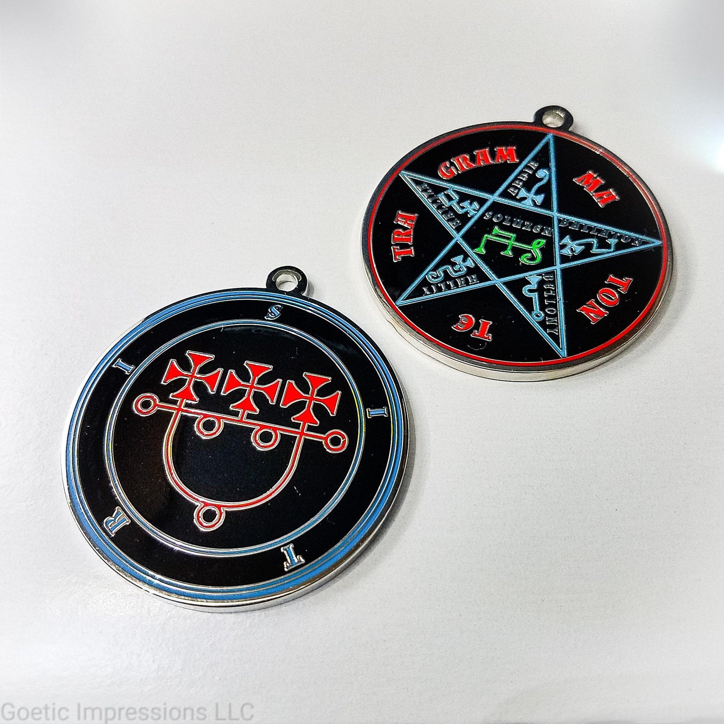 Two medallions showing the front and reverse side of the Goetic Spirit Sitri. The circles and text for Sitri is colored in blue with the sigil in red on a black background. The reverse side is the Pentacle of Solomon with TETRAGRAMMATON text in red, the star and sigils in blue and the center sigil in green. The seal is silver plated.