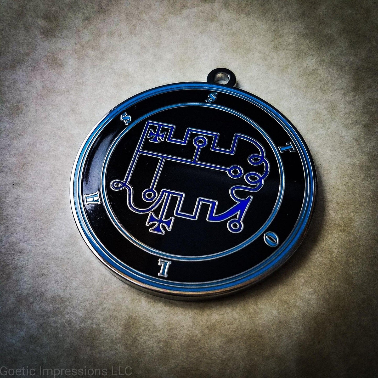 Talisman of goetic spirit Stolas . Stolas's sigil is dark blue with the circles surrounding in teal along with the name on a black background.