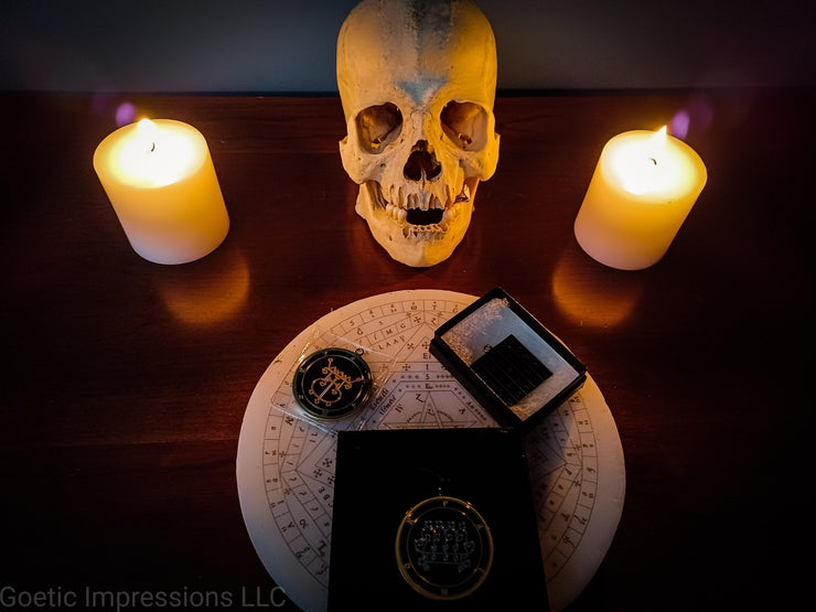 A human skull surrounded by candles with ceremonial ritual tools.