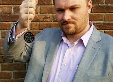 A businessman holding up an occult talisman featuring a pentacle.