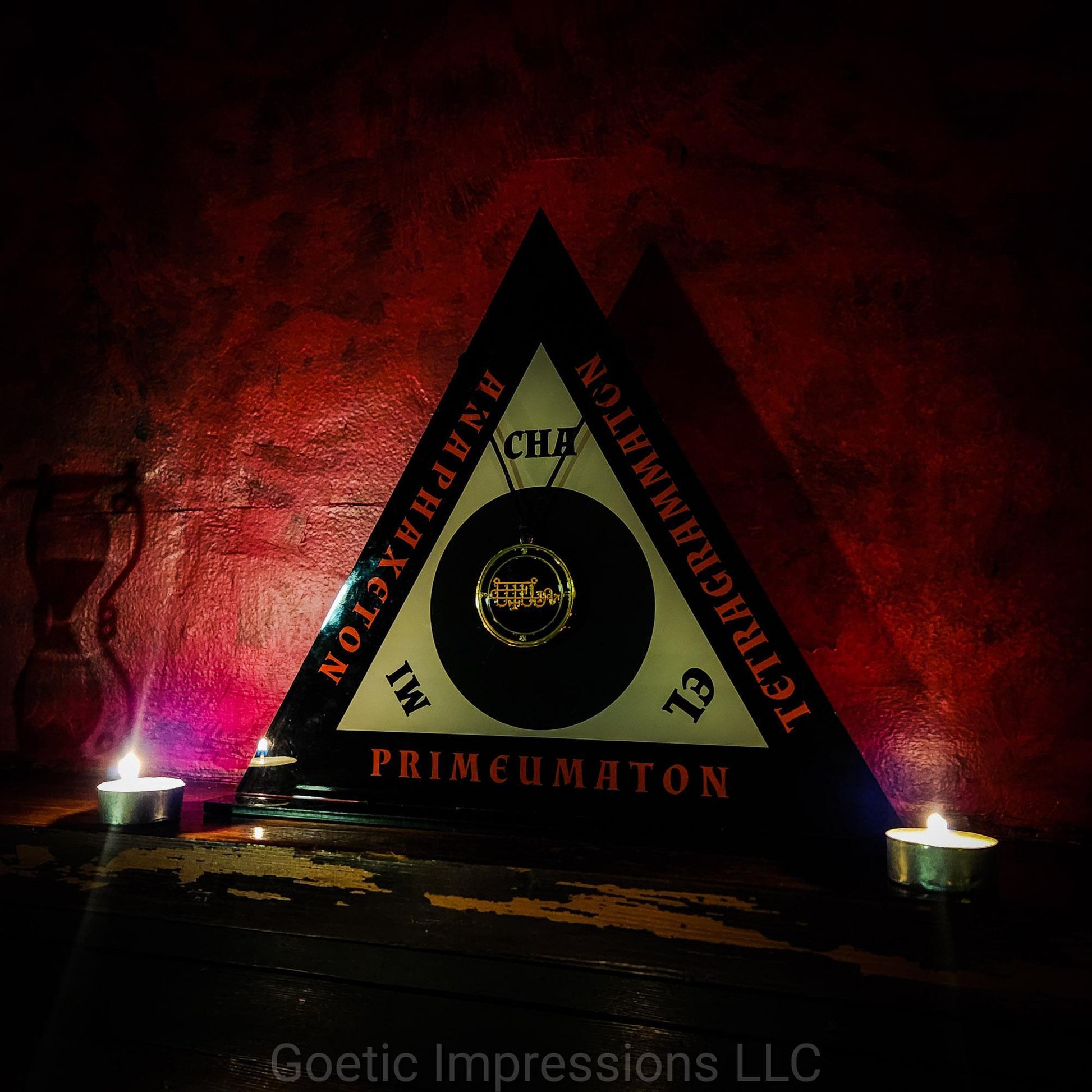 The Magickal Triangle of Solomon between two candles. The Triangle holds a pendant of the goetic spirit Bune.