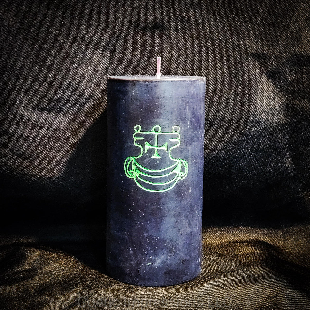 A black 3"x6" pillar candle with a hand carved green sigil of Agares from the Lesser Key of Solomon.