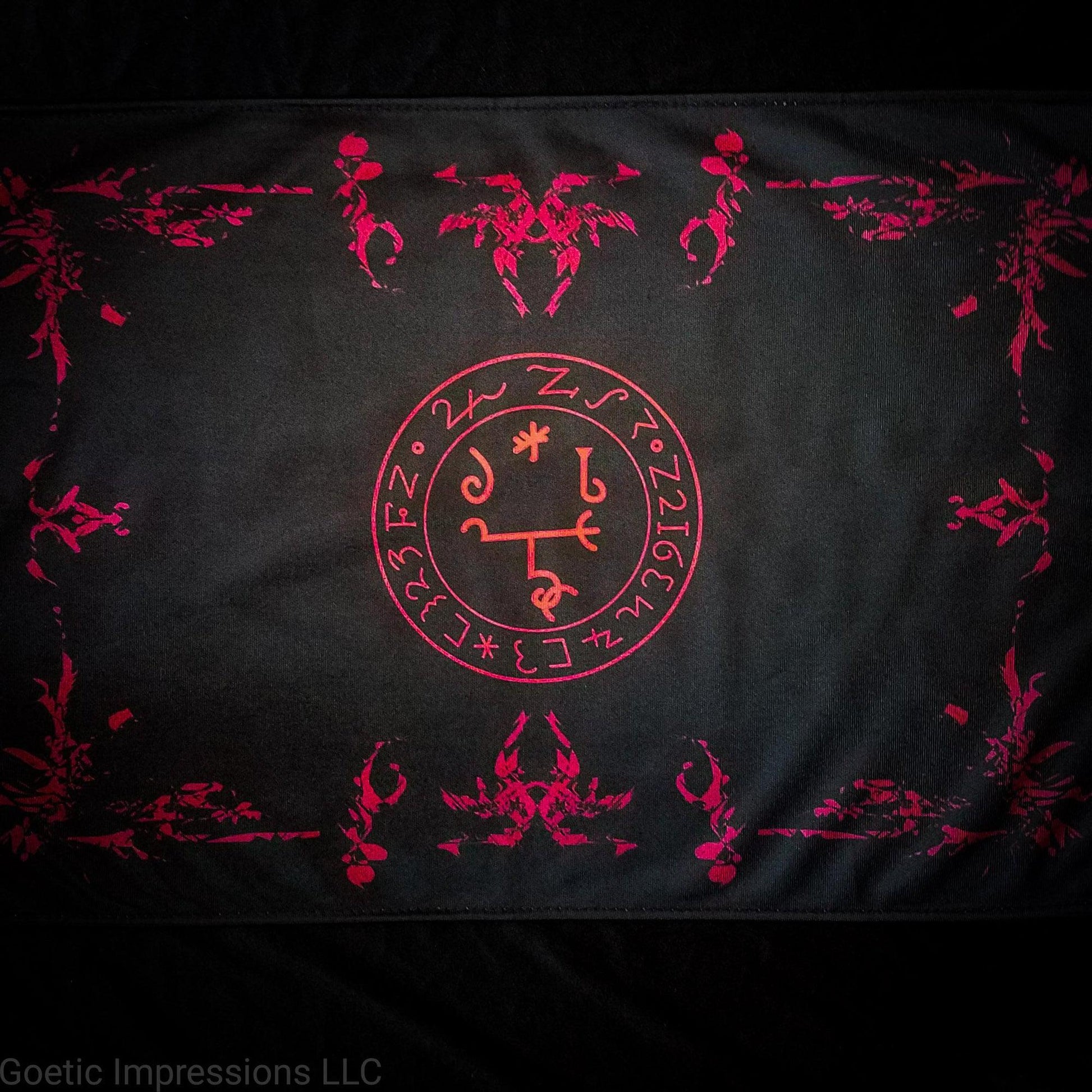 A red and black altar cloth with the sigil of Beelzebub in the center. 