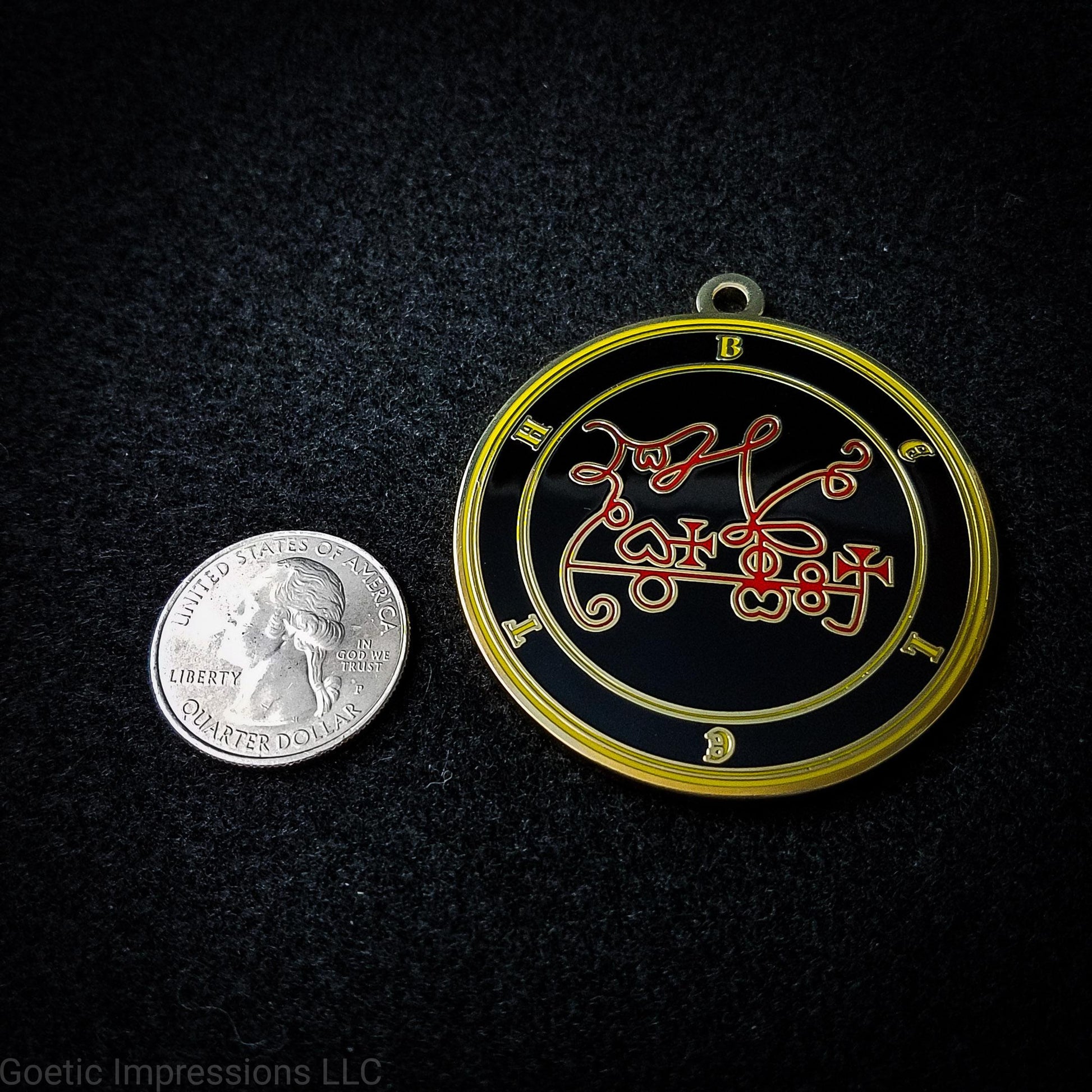Seal of Beleth next to a quarter. The seal medallion measures two inches in diameter. The sigil is red with yellow letters and circles on a black background. 