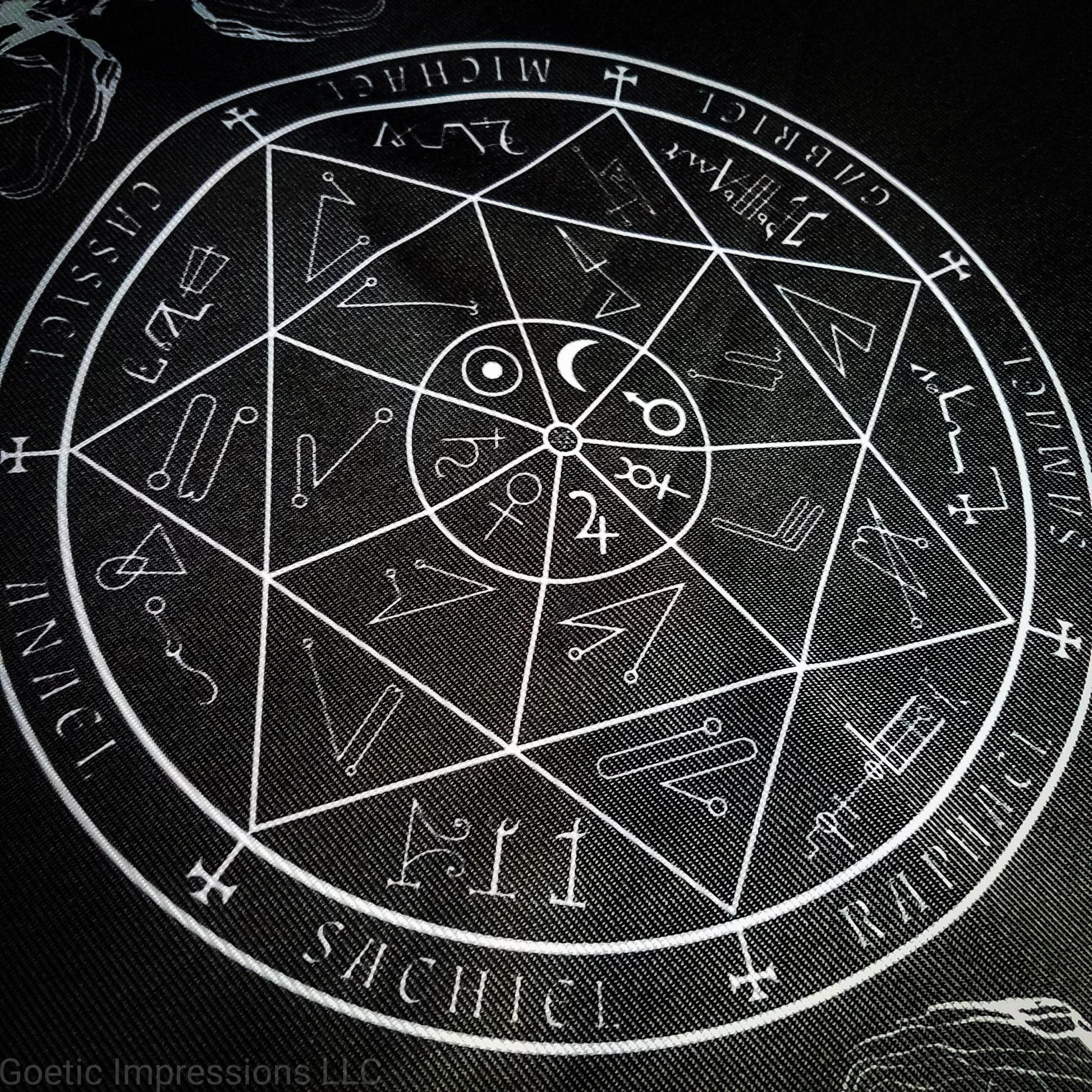 A black and white altar cloth with a seal of the planetary Archangels in the center. The seal contains various astrological sigils.