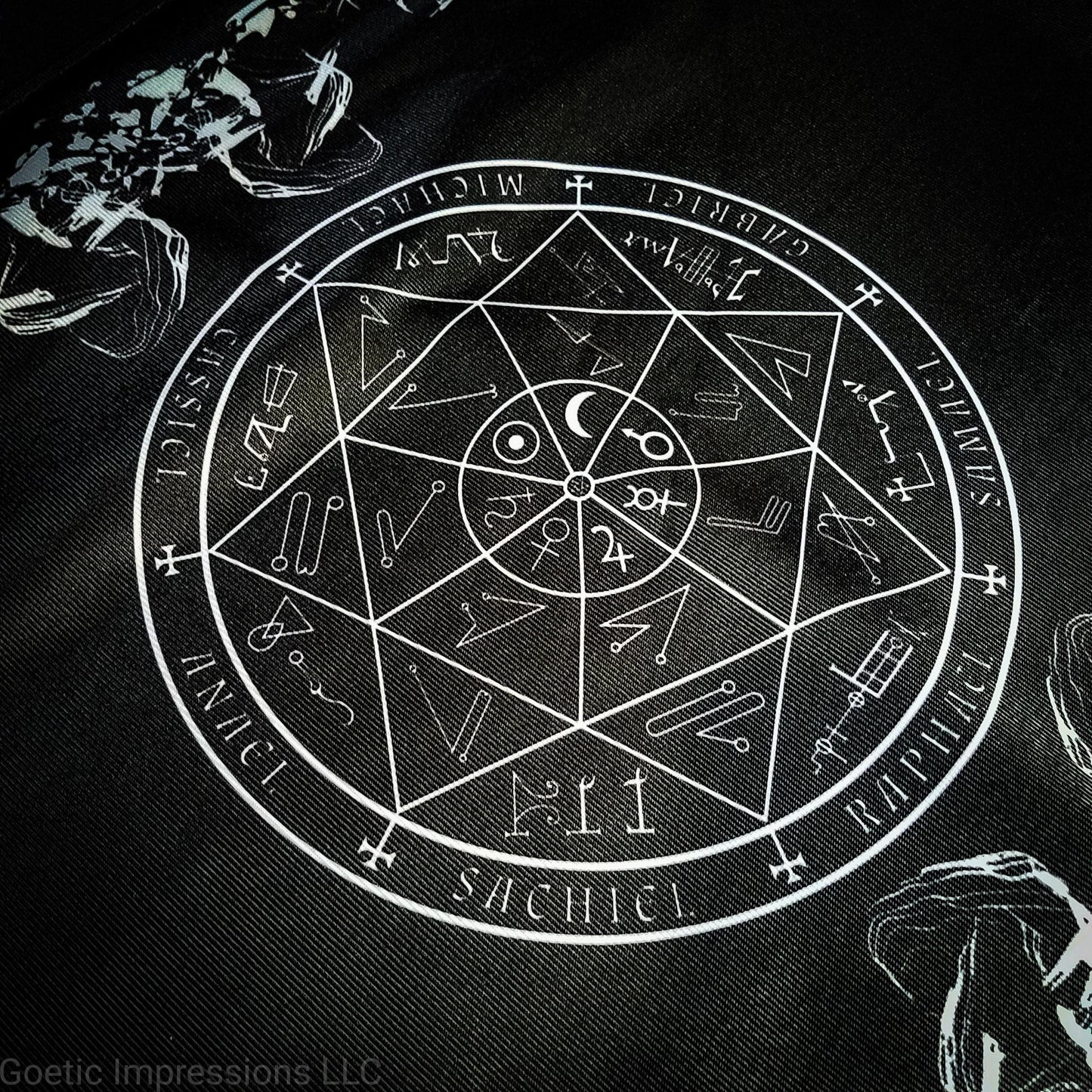 A black and white altar cloth with a seal of the planetary Archangels in the center. The seal contains various astrological sigils.