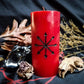 Red pillar candle with Chaos star symbol carved into it.