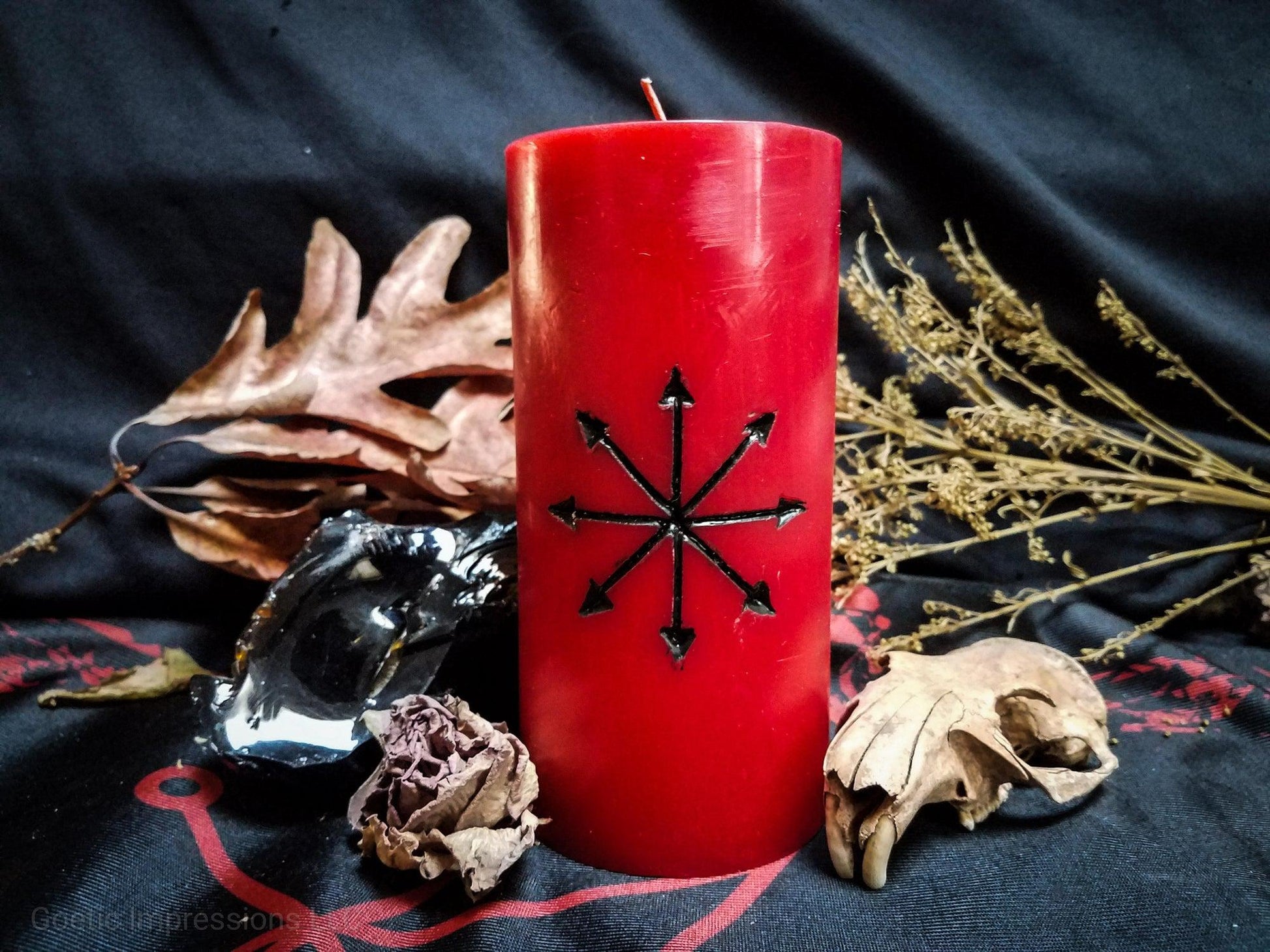 Red pillar candle with Chaos star symbol carved into it.