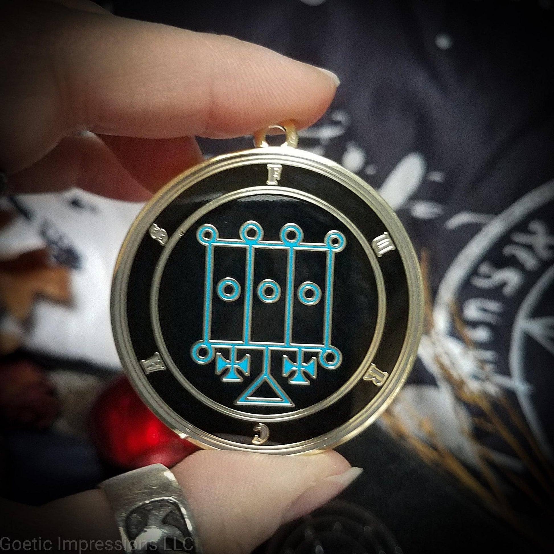 Talisman of goetic spirit Furcas. Furcas's sigil is blue with the circles surrounding in gray along with the name on a black background. 