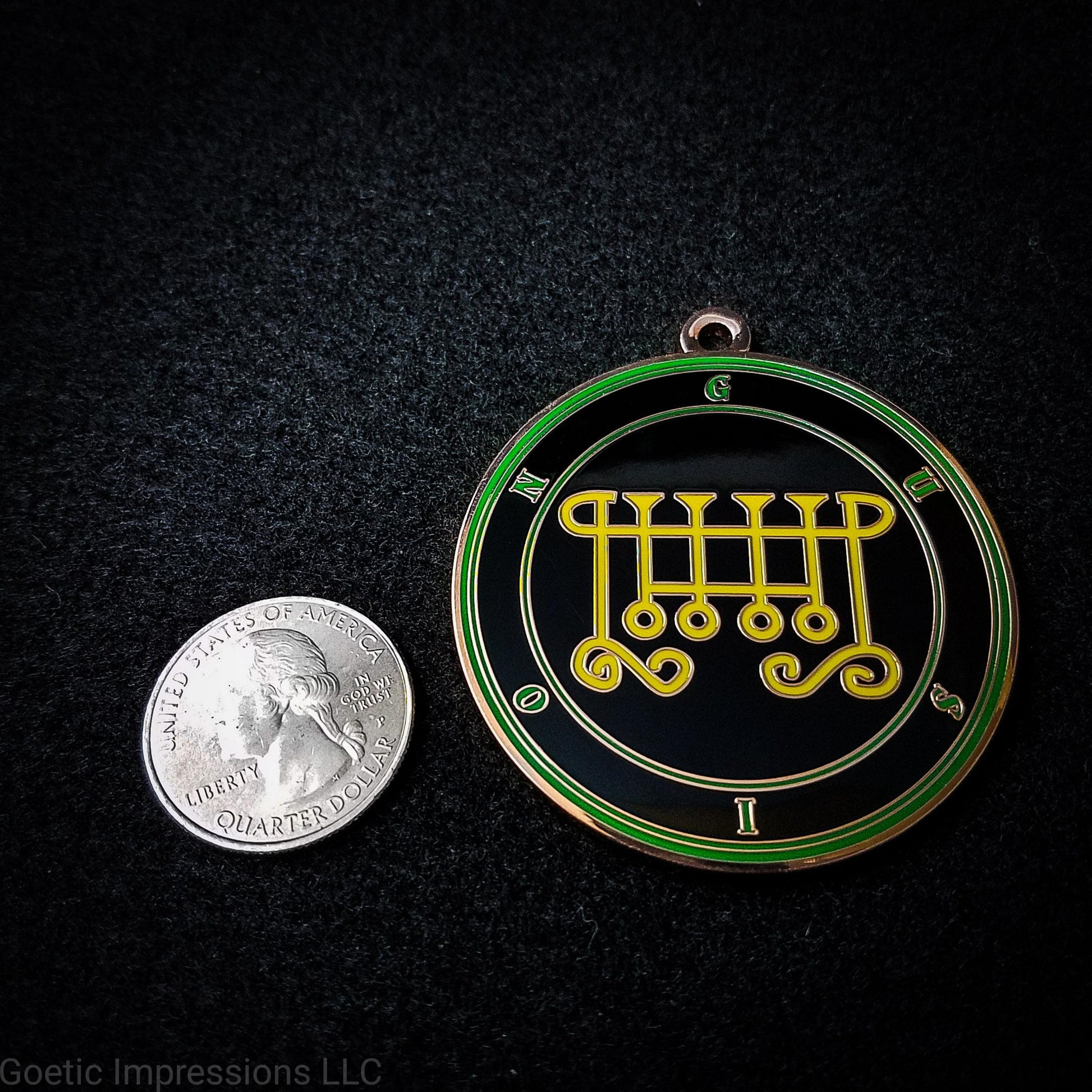 Seal of Gusion next to a quarter. The seal medallion measures two inches in diameter. The sigil is yellow with green letters and circles on a black background. 