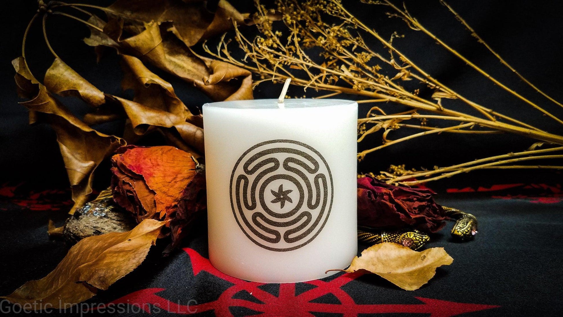 A while candle with a black imprinted design of the Stropholos or Wheel of Hecate
