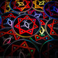 A pile of three inch circular holographic stickers. The stickers have a black background and a white  and red symbol featuring the Star of Babalon. The holographic paper shines in a wide arrange of rainbow colors when the light catches it at different angles. 
