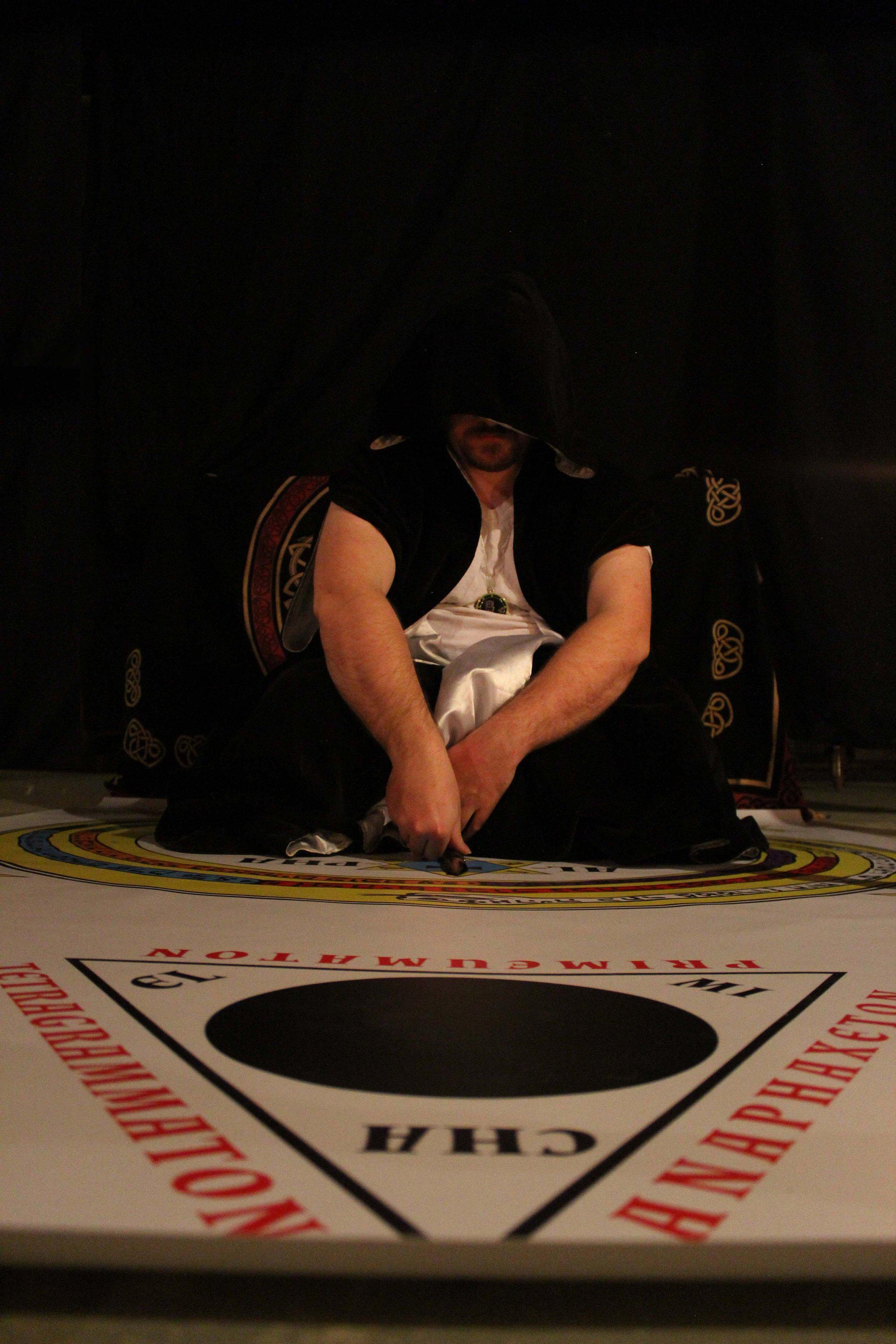 Magician commanding a spirit into the circle of the lesser key of solomon summoning circle mat.