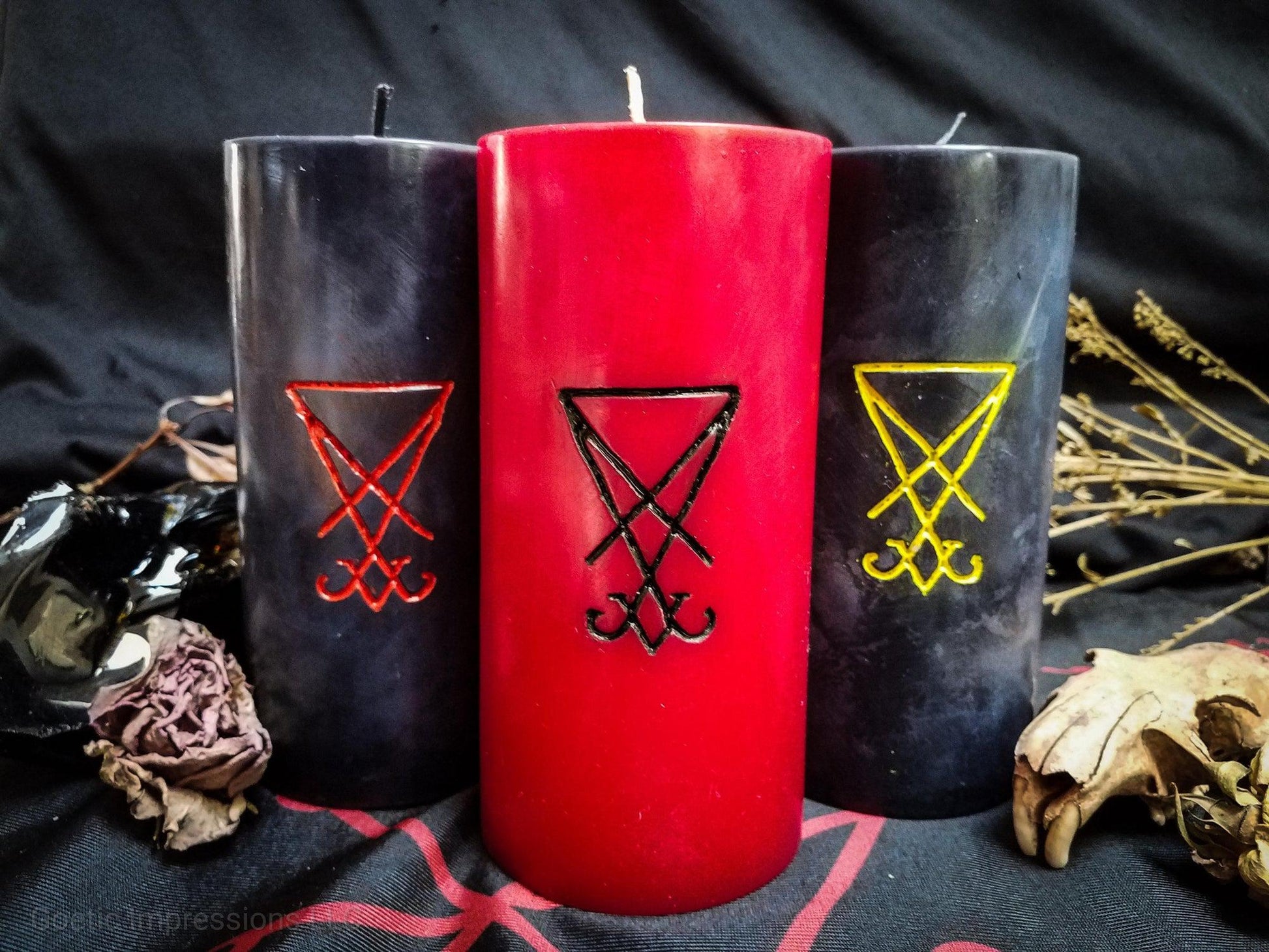 Pillar candles with Lucifer sigils carved into them.