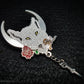 Lupercalia pin featuring a white wolf with a crescent moon in the background. The wolf is holding a rose, leather strips and has a chain with a dagger attached to it. It is plated in silver.