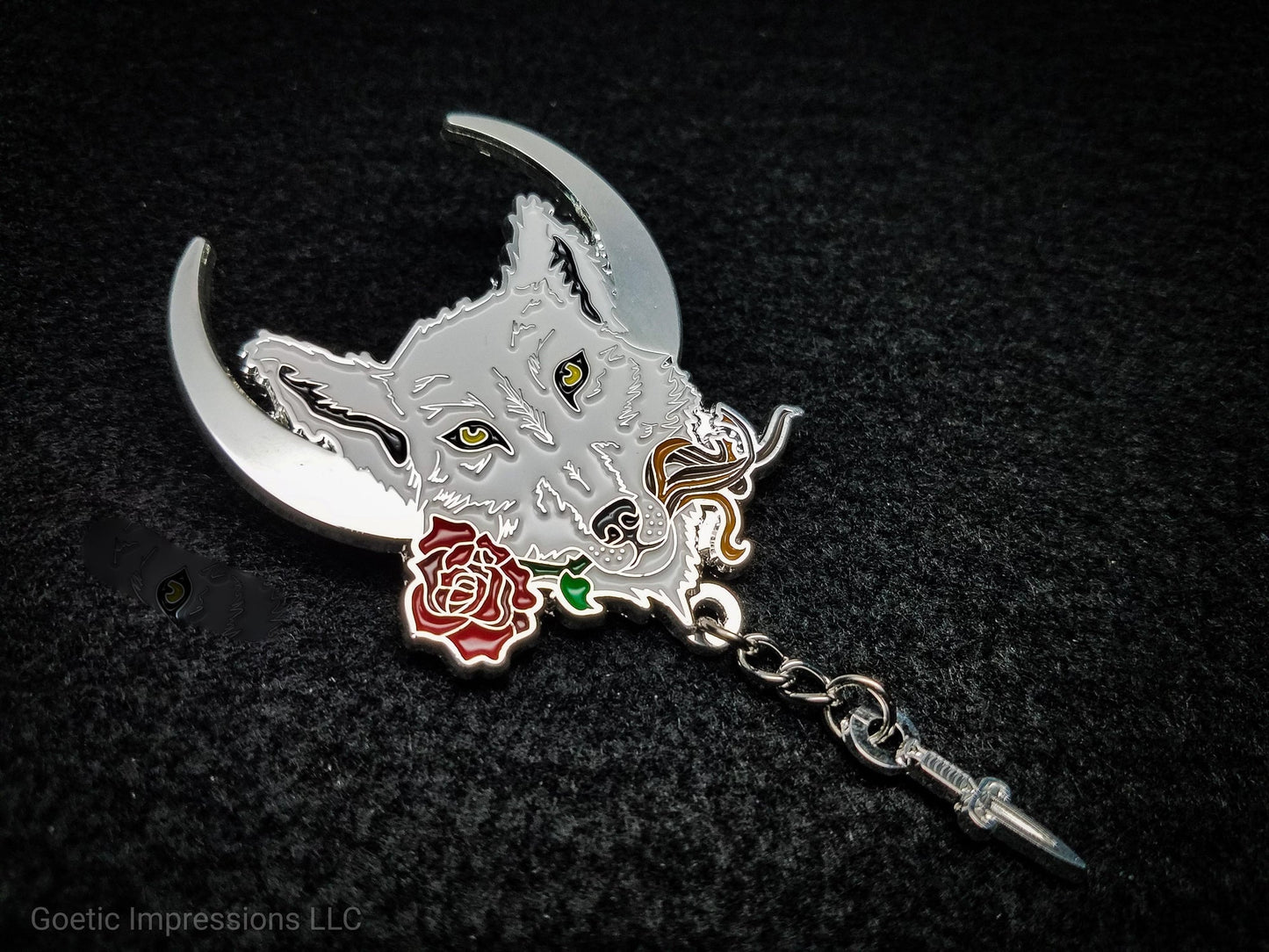 Lupercalia pin featuring a white wolf with a crescent moon in the background. The wolf is holding a rose, leather strips and has a chain with a dagger attached to it. It is plated in silver.