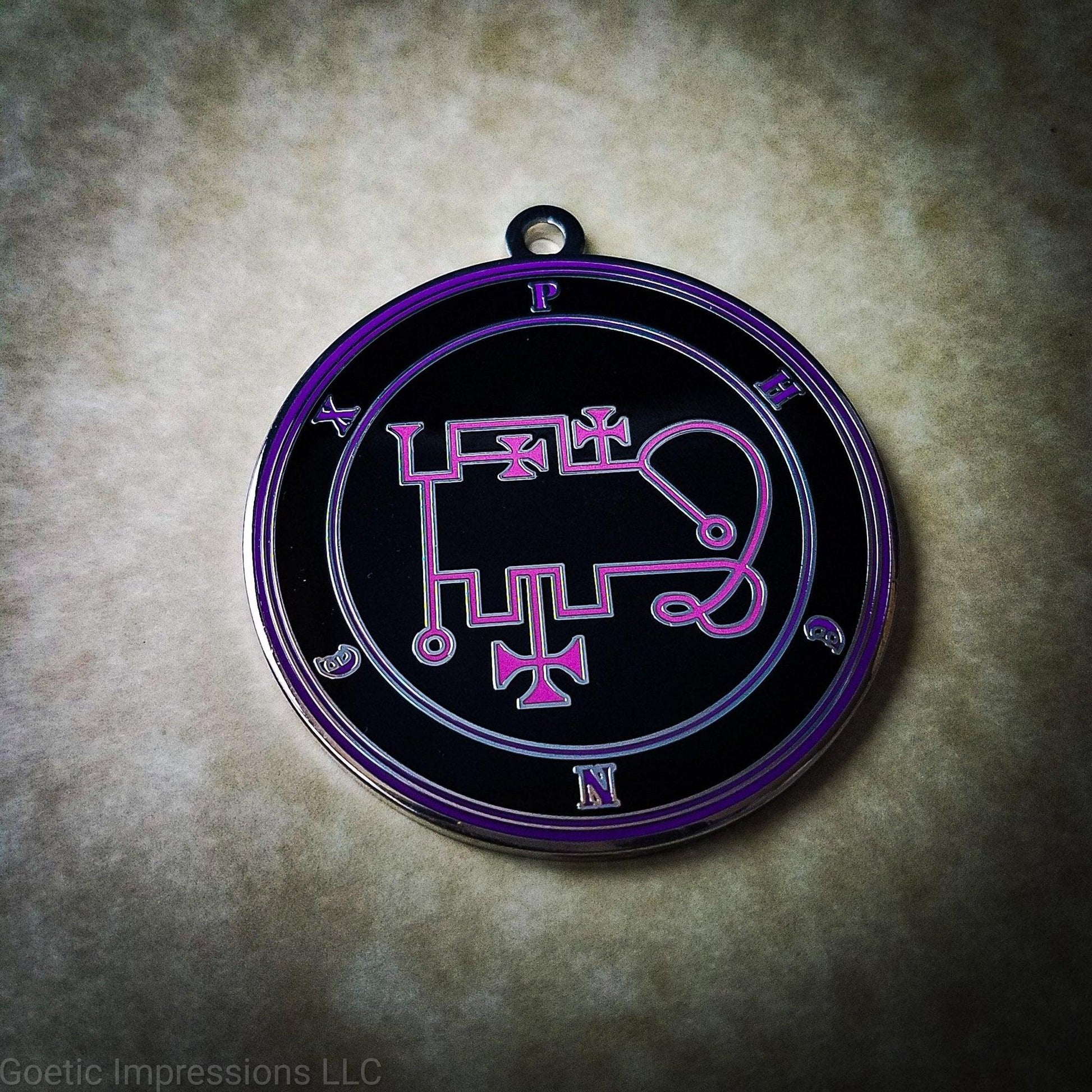 Talisman of goetic spirit Phenex. Phenex's sigil is pink with the circles surrounding in purple along with the name on a black background. 