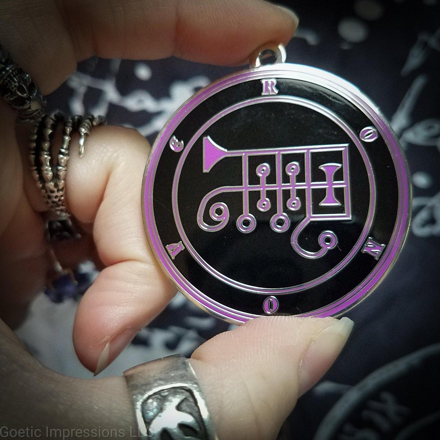 Talisman of goetic spirit Ronove. Ronove's sigil is purple with the circles surrounding in purple along with the name on a black background. 