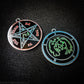 Two medallions featuring the front and back of the Ars Goetia spirit Seere. The sigil is green with the name and circle surrounding in blue.  The Reverse is the TETRAGRAMMATON.  The pentacle is blue with a red circle.  Tetragrammaton is in red. The center sigil is green. The seal is plated in silver.