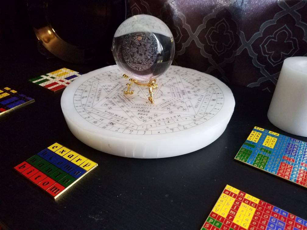 Enochian altar setup with Sigillum Dei Aemeth crystal ball on top of a larger wax sigillum dei aemeth. Surrounded by enochian watchtower tablets and tablet of union