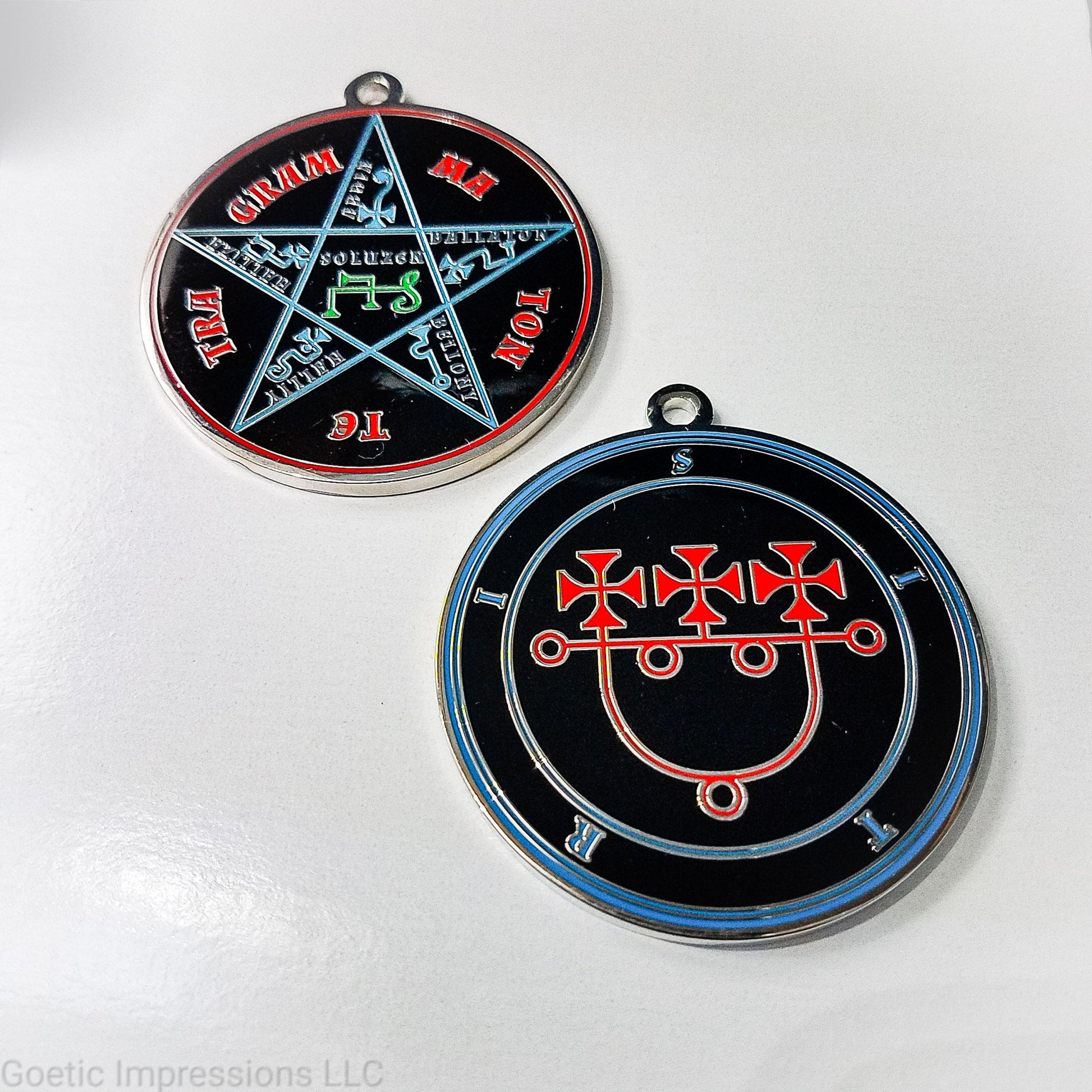 Two medallions showing the front and reverse side of the Goetic Spirit Sitri. The circles and text for Sitri is colored in blue with the sigil in red on a black background. The reverse side is the Pentacle of Solomon with TETRAGRAMMATON text in red, the star and sigils in blue and the center sigil in green. The seal is silver plated.