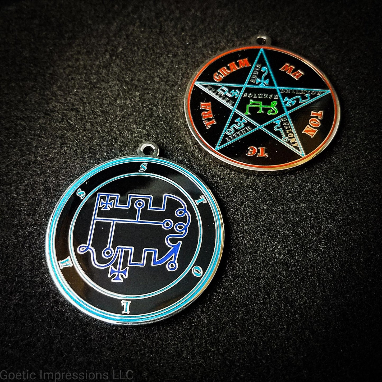 Two medallions featuring the front and back of the Ars Goetia spirit Stolas. The sigil is dark blue with the name and circle surrounding in teal. The Reverse is the TETRAGRAMMATON. The pentacle is blue with a red circle. Tetragrammaton is in red. The center sigil is green. The seal is plated in silver.