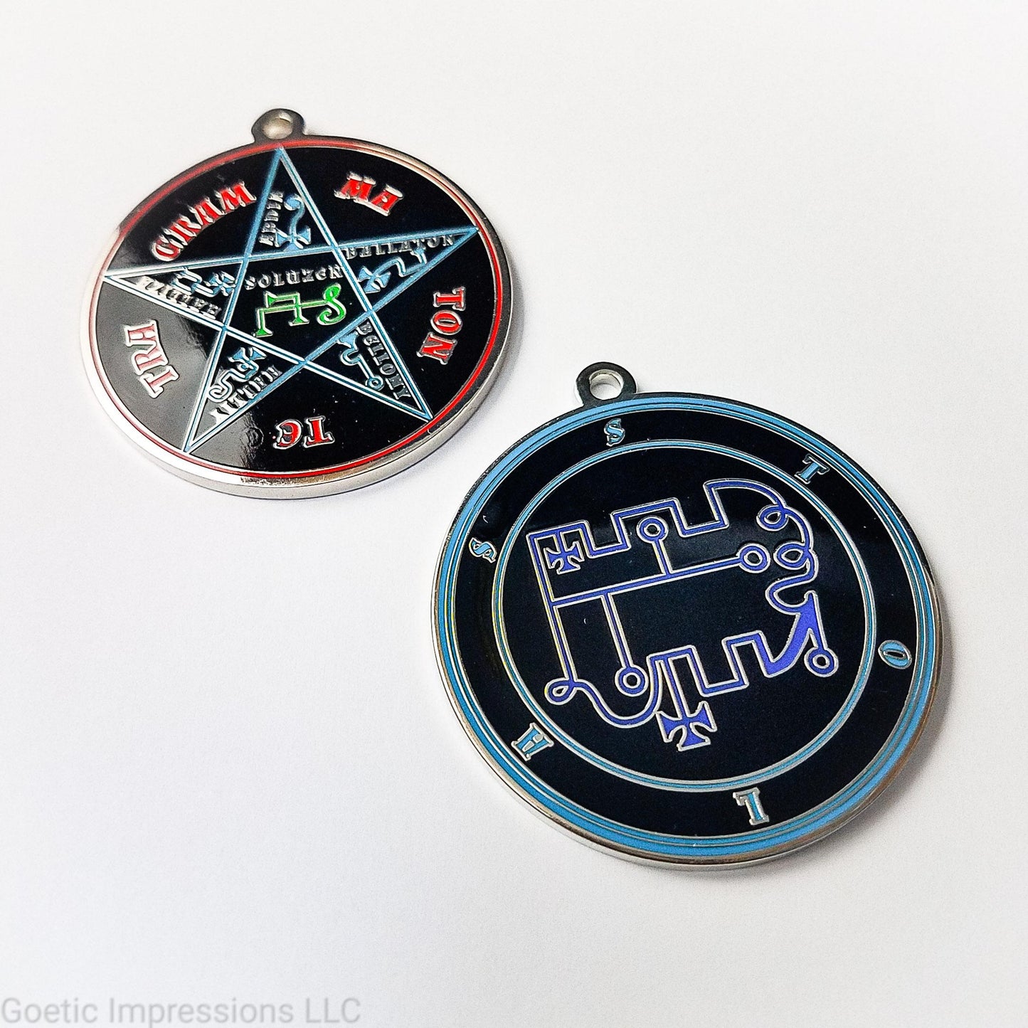 Two medallions featuring the front and back of the Ars Goetia spirit Stolas. The sigil is dark blue with the name and circle surrounding in teal. The Reverse is the TETRAGRAMMATON. The pentacle is blue with a red circle. Tetragrammaton is in red. The center sigil is green. The seal is plated in silver.