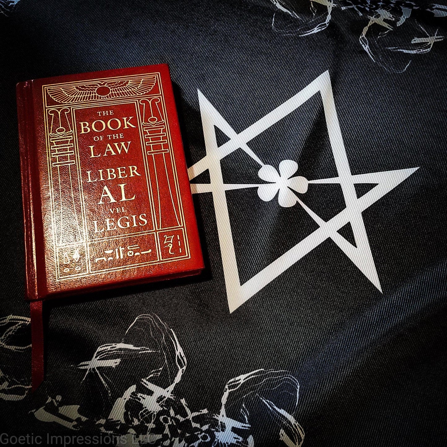 A black and white altar cloth with the Aleister Crowley Unicursal Hexagram from Thelema. The Book of the Law is on the altar cloth. 